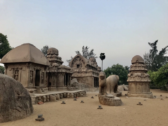 Das Foto zeigt die fünf Rathas in Mahabalipuram, bestehend aus Draupadi, Arjuna, Bhima, Dharmaraja sowie Nakula Sahadeva Ratha (von links nach rechts). Alle während der Herrschaft von Pallava König Narasimhavarman dem Ersten (630 bis 668) im verkleinerten Maßstab als Experimentalbauten errichtet.